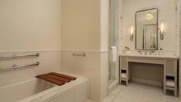 A modern bathroom with a bathtub, a vanity with a mirror, and a shower area.