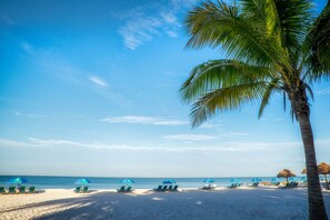 On the beach, white sand, sun loungers, beach umbrellas