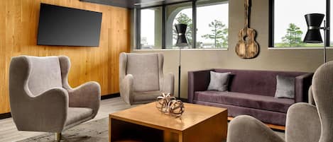 A modern living room with a flat-screen TV, a wooden coffee table, and a sofa.