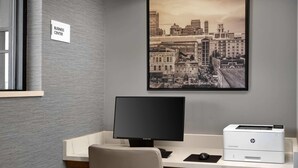 A business center desk with a computer monitor, HP printer, and a framed cityscape photo on the wall. - Radisson Hotel West Memphis (West Memphis)