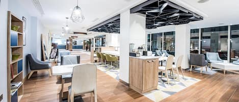 A modern interior with a reception desk, seating area, and a kitchen counter.