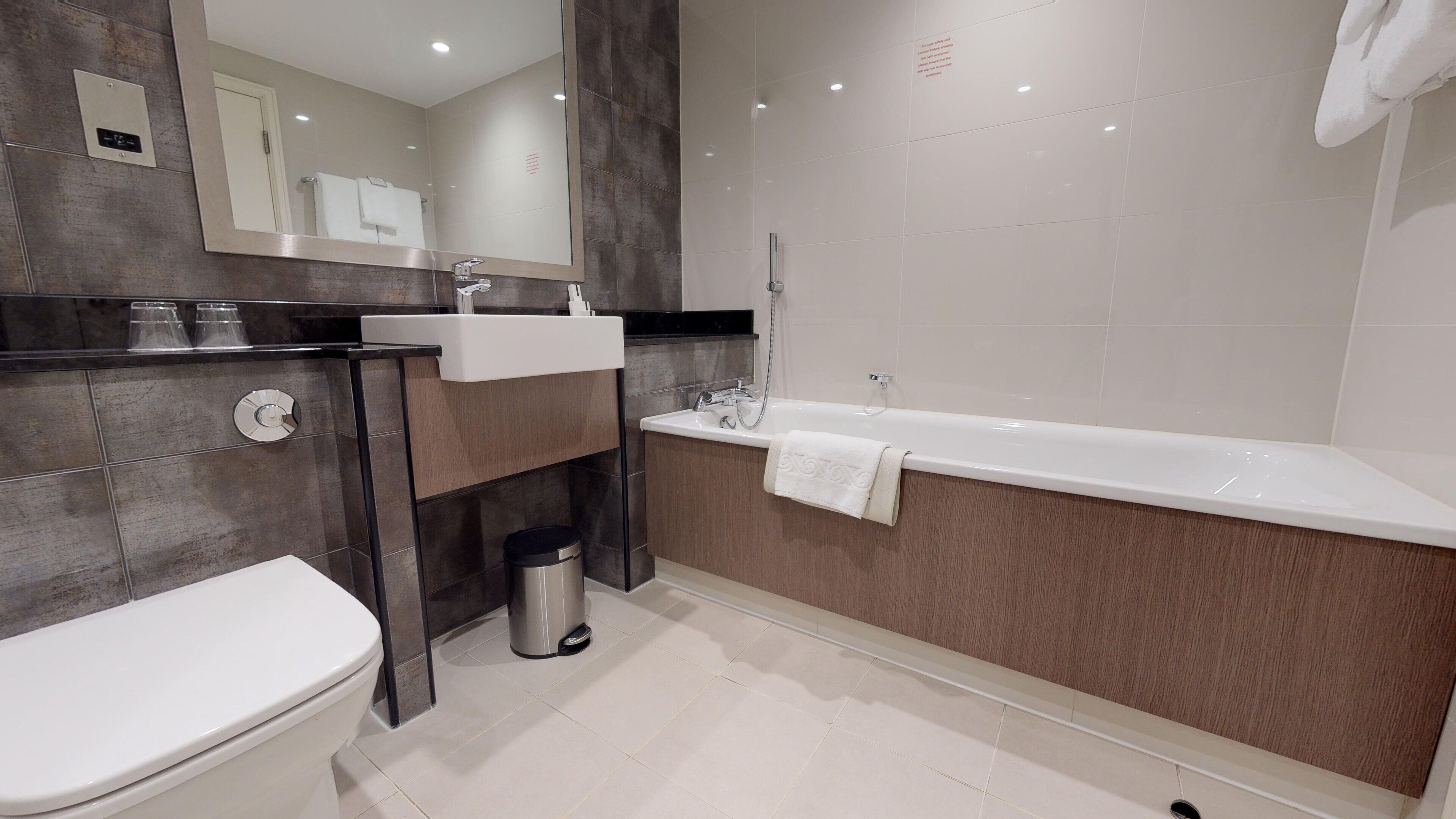 A modern bathroom with a toilet, sink, and bathtub.