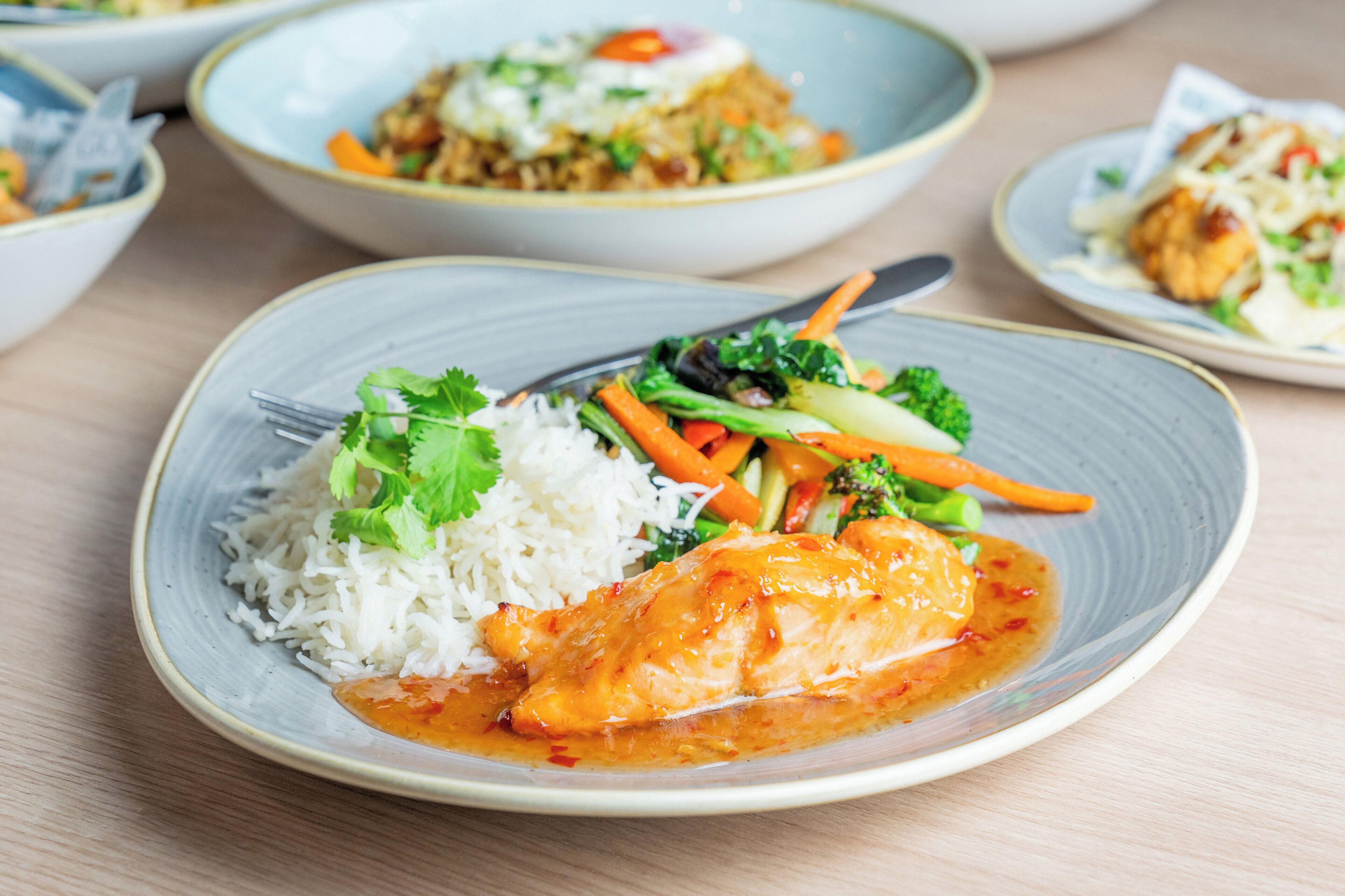 A plate of food with rice, vegetables, and a piece of chicken.