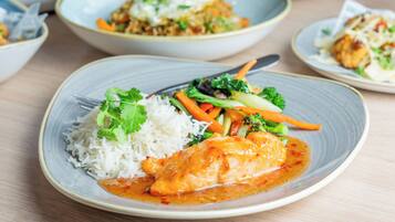 A plate of food with rice, vegetables, and a piece of chicken.