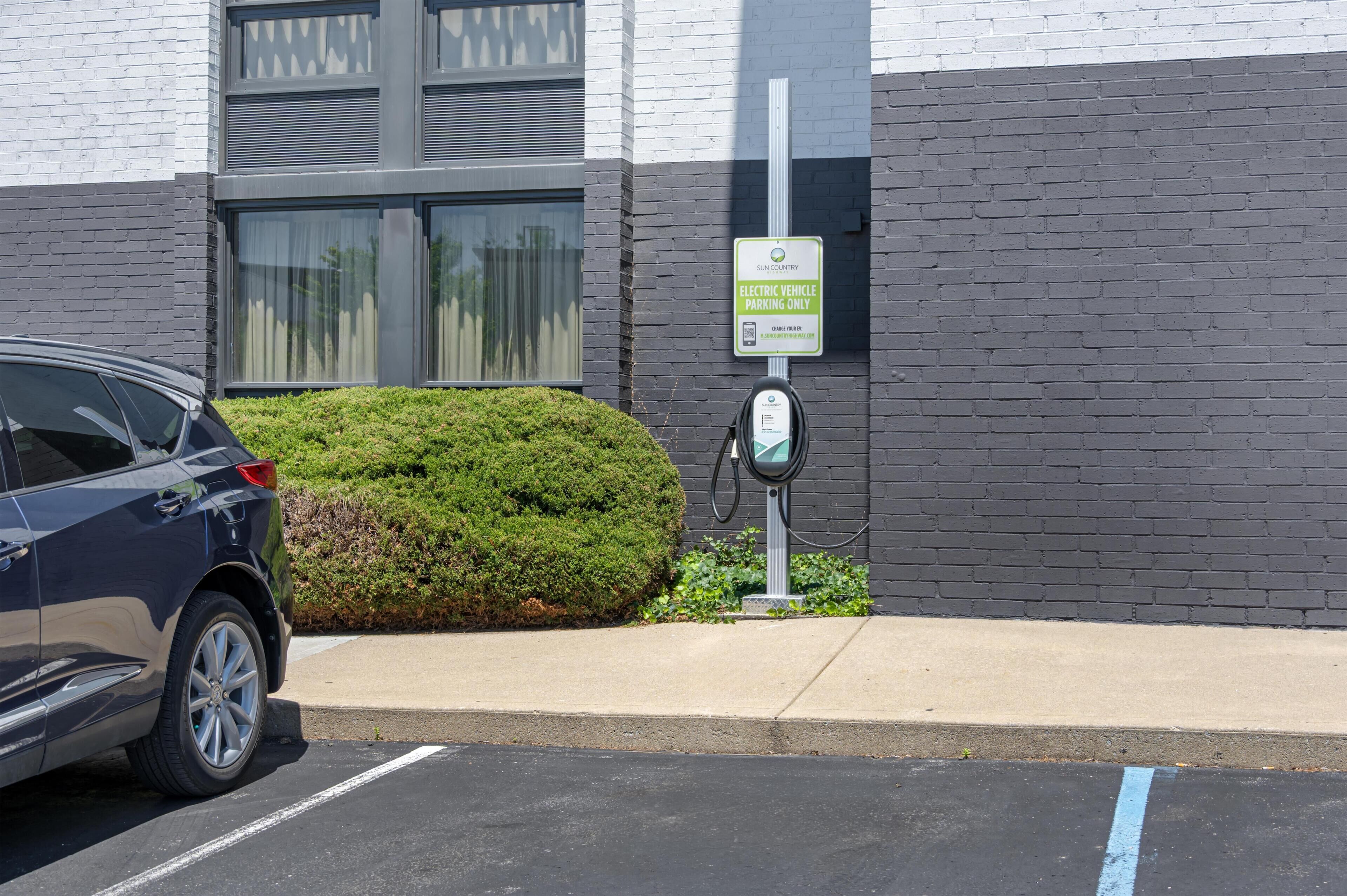 A parking area with a sign indicating electric vehicle charging.