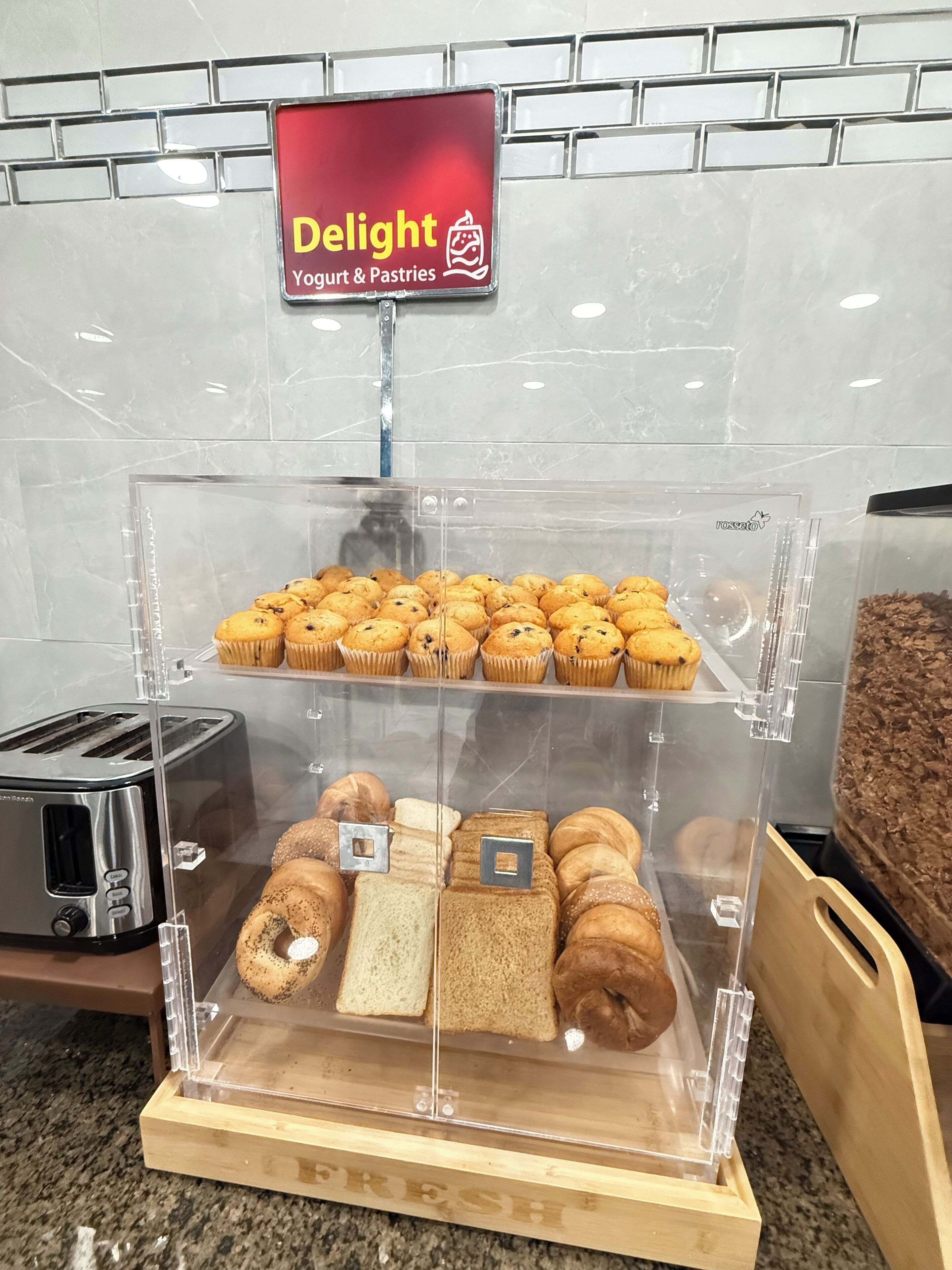A bakery display with muffins, bread, and pastries.
