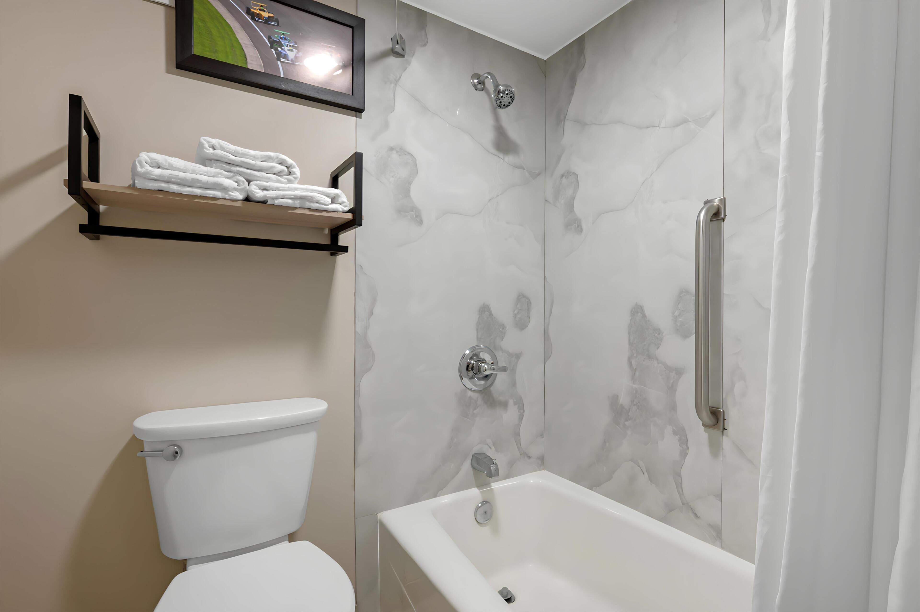 A bathroom with a toilet, a shower with a glass door, and a bathtub.