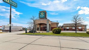 A Quality Inn by Choice Hotels with a clear sky and a parking lot in front.