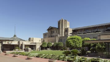 Un bâtiment doté d’une tour imposante et d’une vaste cour intérieure agrémentée de jardinières et d’arbres.