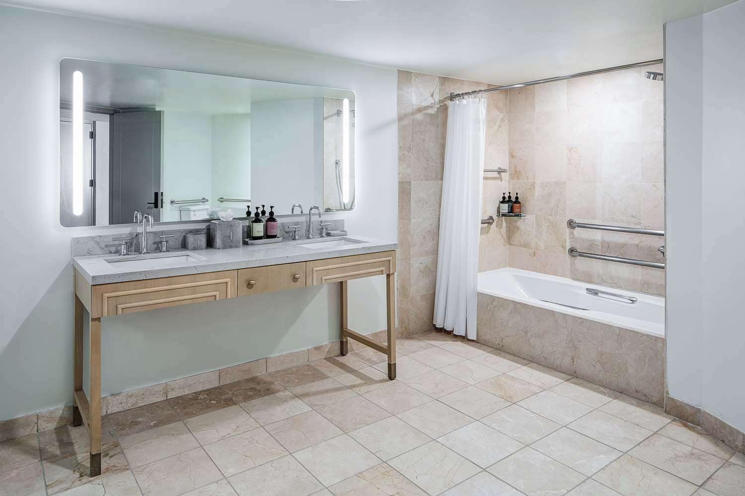 Une salle de bain moderne avec un meuble-lavabo à deux vasques, un grand miroir, une baignoire et un espace douche.