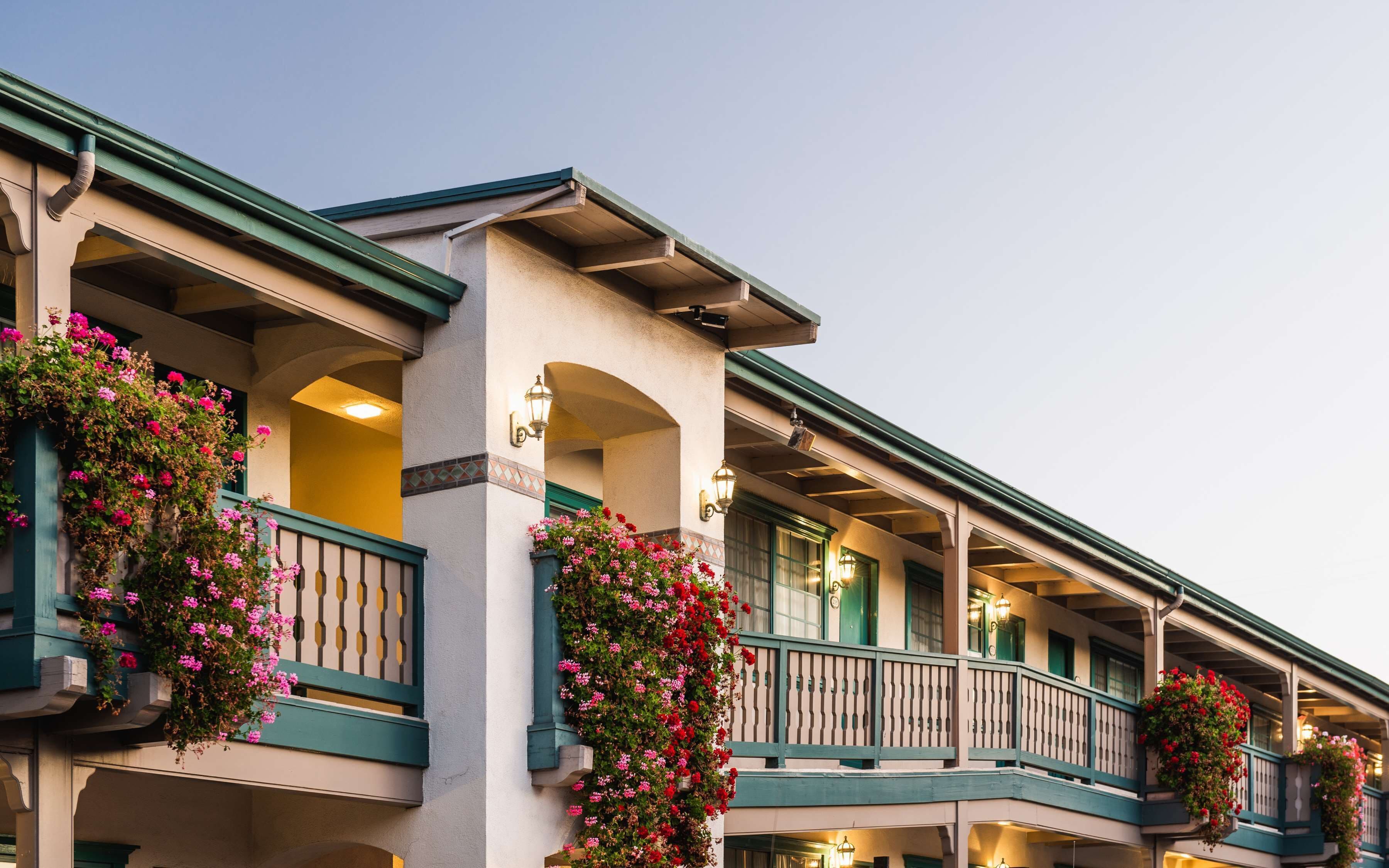 Un hotel con varios balcones decorados con cestas de flores colgantes.