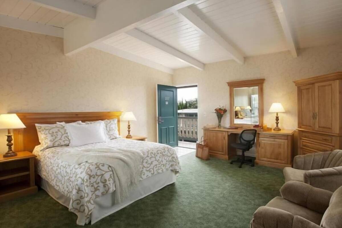 Une chambre à coucher comprenant un lit, un bureau, une chaise et une armoire.