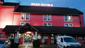 Un edificio rojo con un cartel que dice "ENZO HOTELS" en la parte superior.