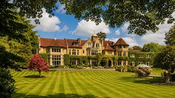 A large, stately building with multiple towers and a well-manicured lawn.