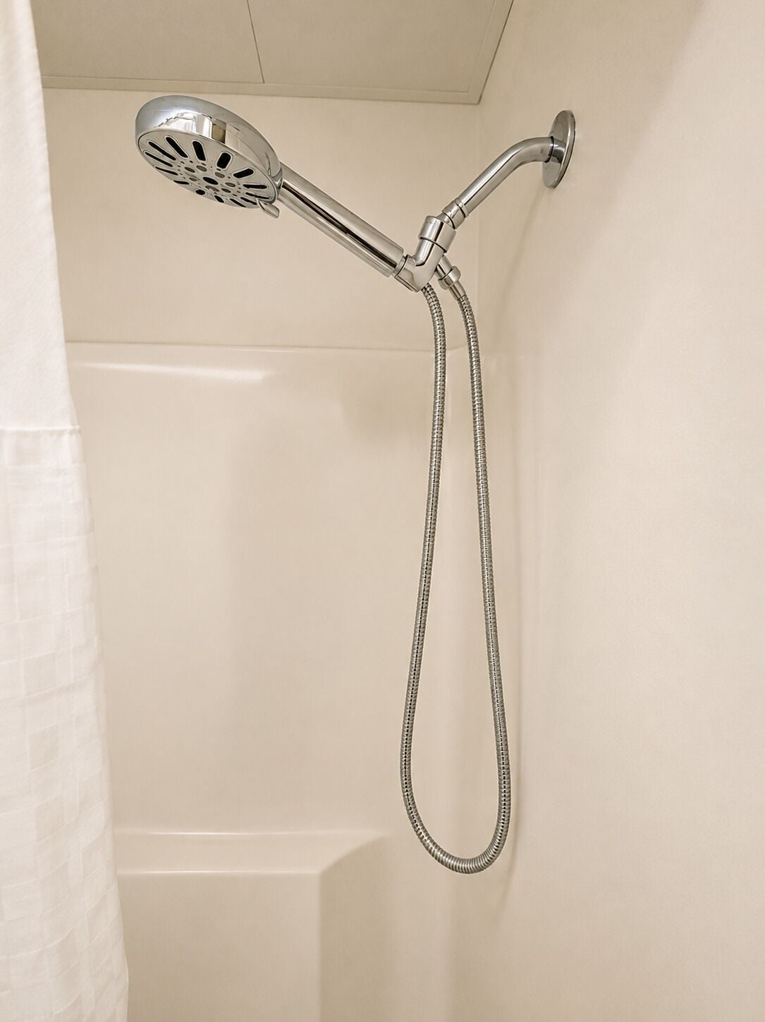 A shower with a handheld showerhead and a flexible hose.