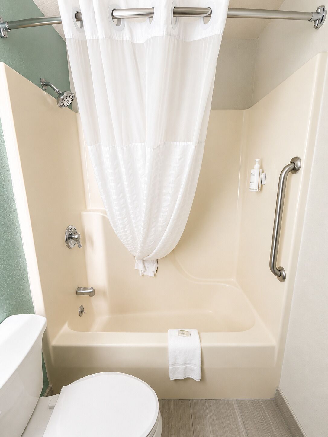 Une salle de bain avec une baignoire, des toilettes et un rideau de douche.
