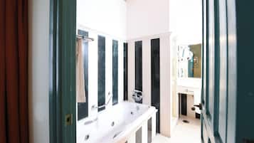 Un baño con una bañera blanca, un espejo y un lavabo.