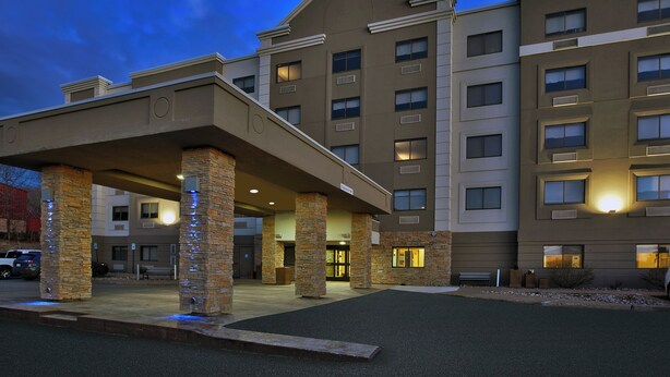 A multi-story hotel with a covered entrance, stone pillars, and a parking area. - Holiday Inn Express Sault Ste. Marie by IHG (Sault Ste. Marie)