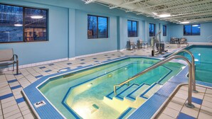 An indoor swimming pool with clear water, tiled floor, and a lifeguard chair. - Holiday Inn Express Sault Ste. Marie by IHG (Sault Ste. Marie)