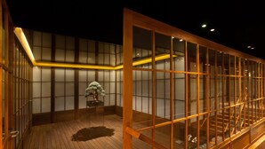 Une pièce de style japonais traditionnel, avec un sol recouvert de tatamis, des portes coulissantes et un escalier en bois.
