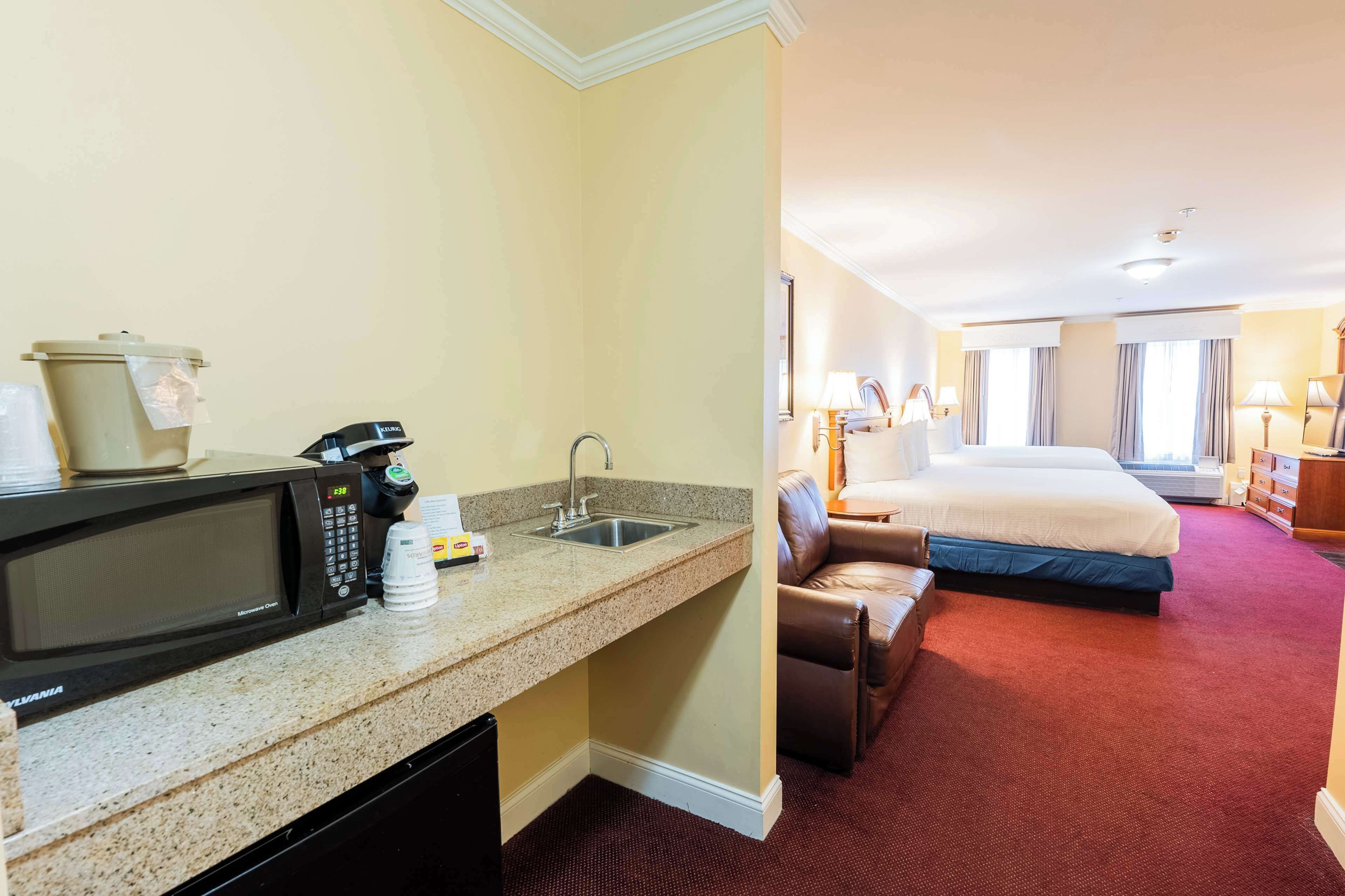 Une chambre d’hôtel équipée d’une kitchenette, d’un lit, d’un canapé et offrant une vue sur la ville.