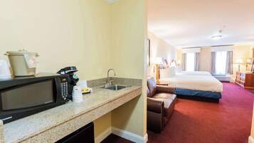 Une chambre d’hôtel équipée d’une kitchenette, d’un lit, d’un canapé et offrant une vue sur la ville.