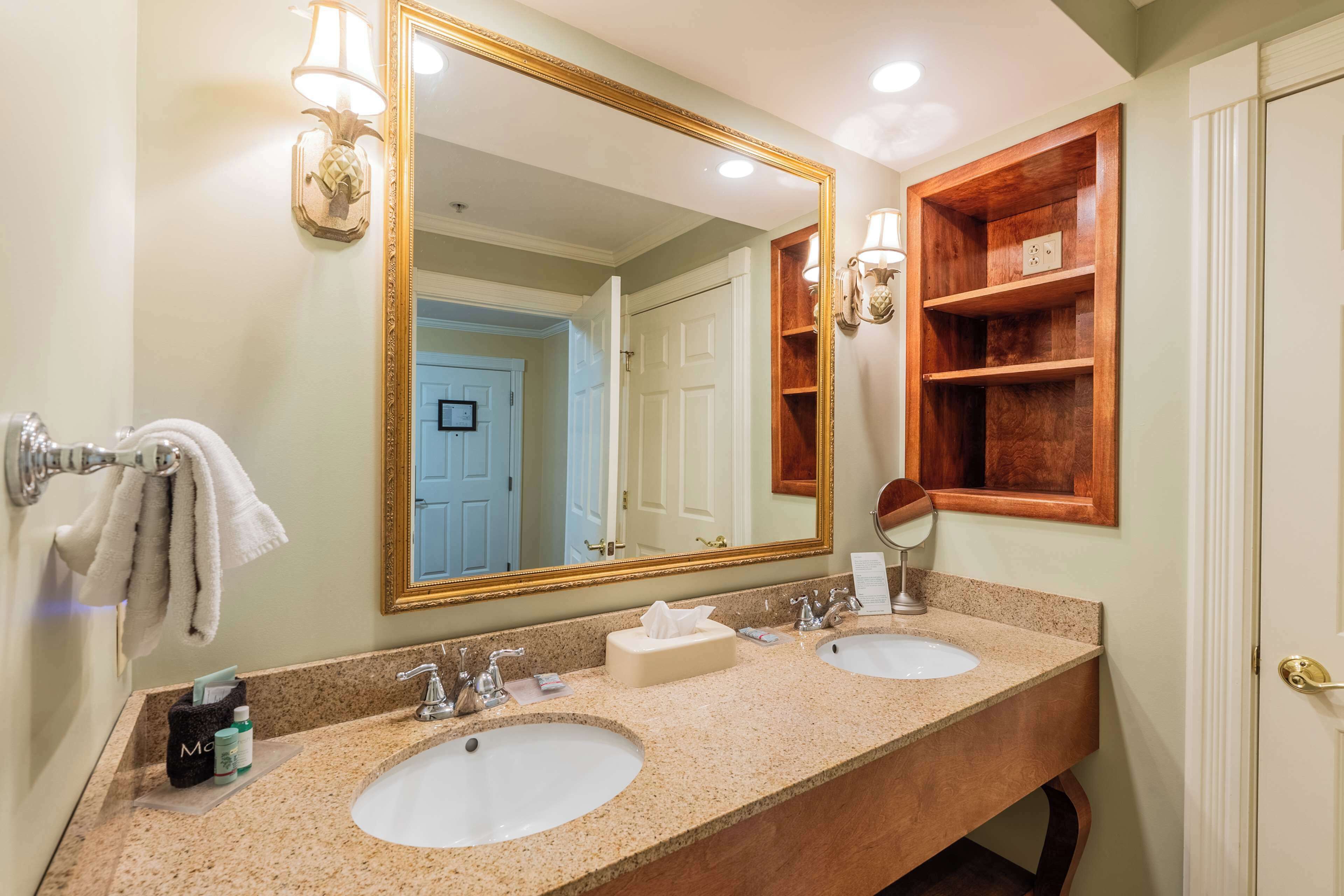 A bathroom with two sinks, a large mirror, and a wooden shelf.