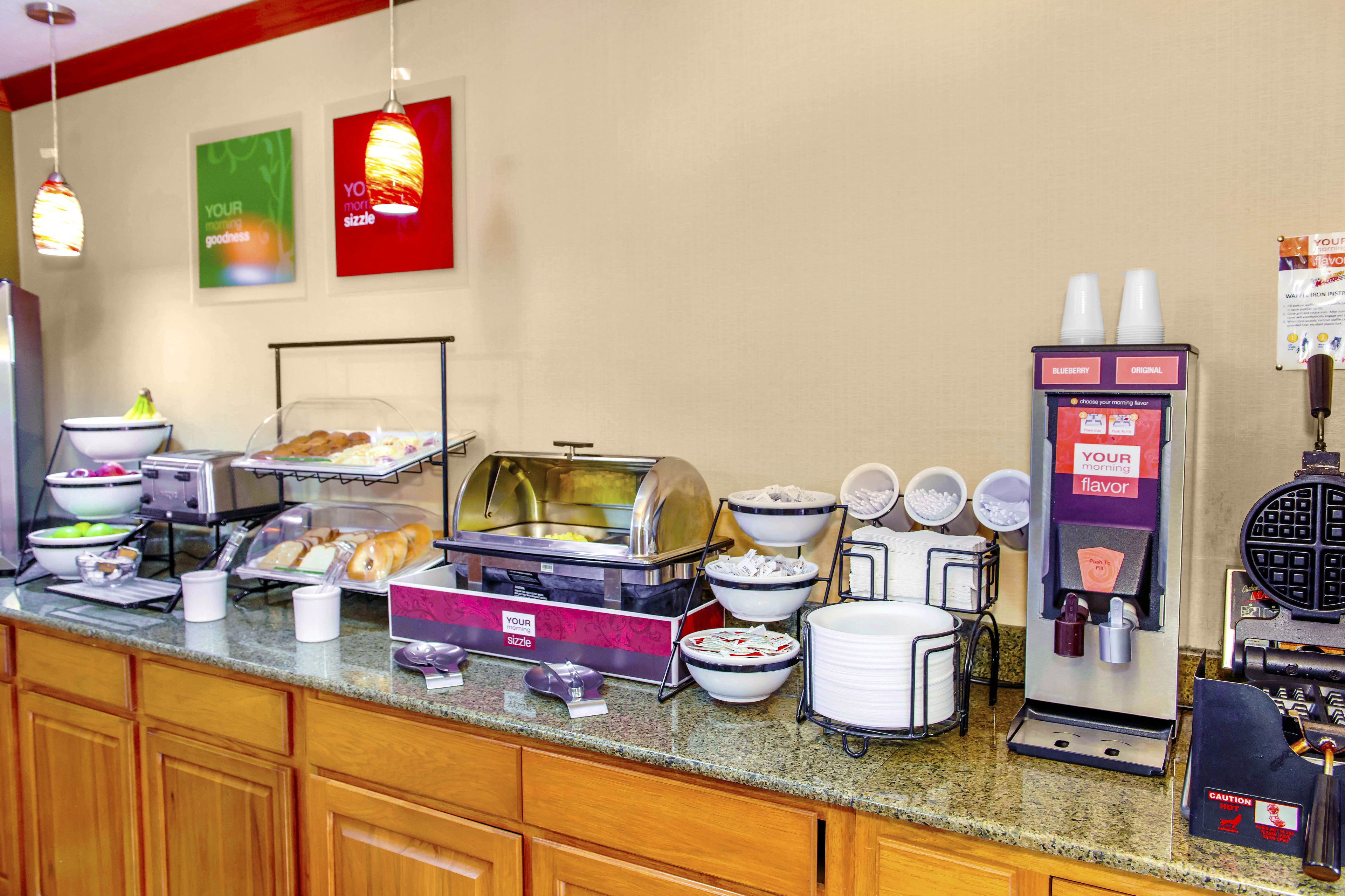 A buffet setup with various food items, a coffee machine, and a sign indicating 'Your Morning Flavor'.