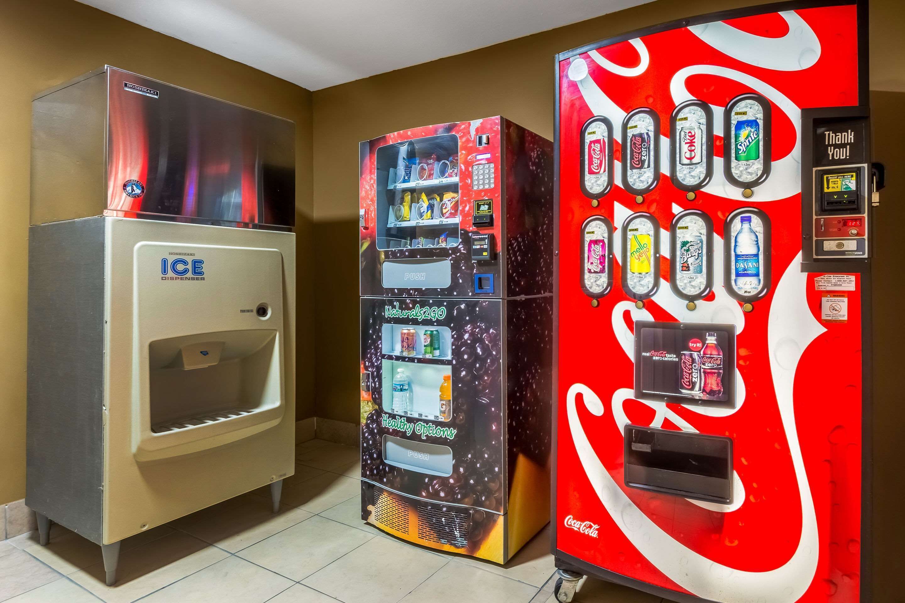 A vending machine with a Coca-Cola logo, a water dispenser, and a selection of beverages.
