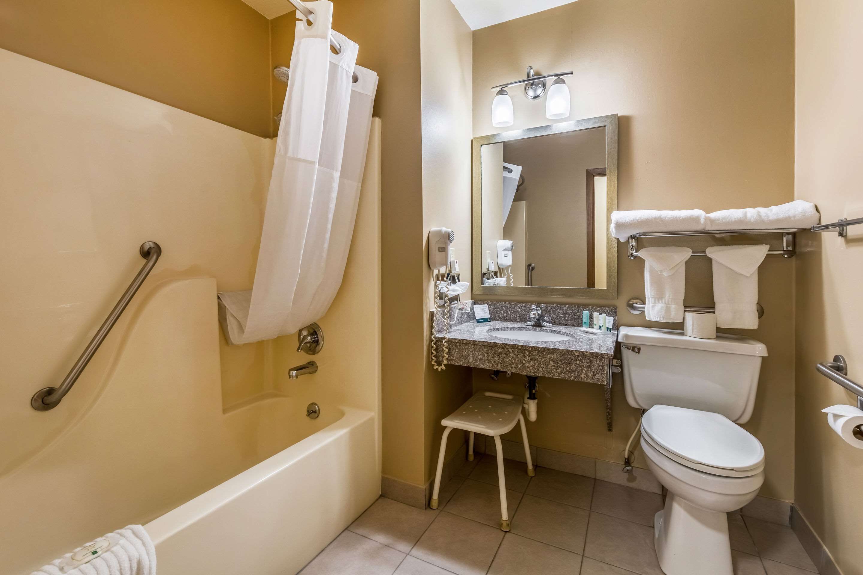 Een badkamer met een bad, toilet, wastafel en douche.