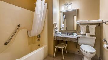 Een badkamer met een bad, toilet, wastafel en douche.