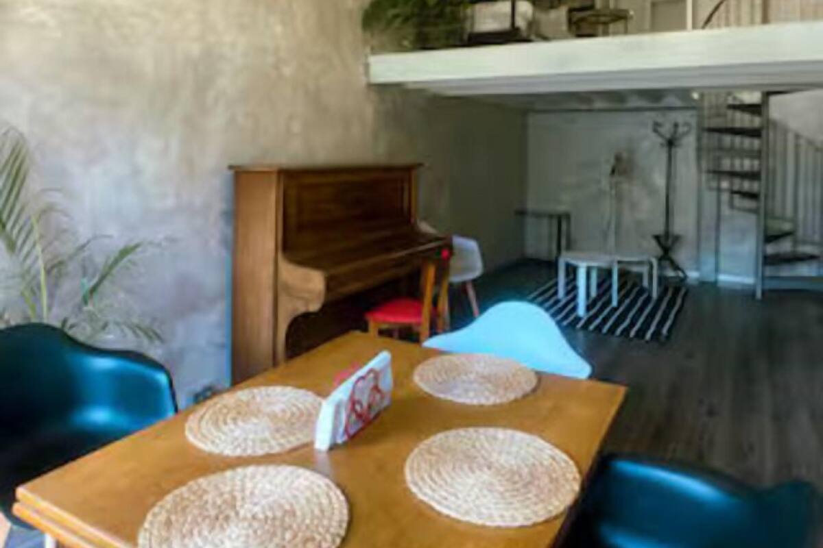 A dining area with a wooden table, woven placemats, and blue chairs.