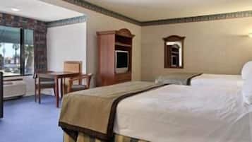 A hotel room with a bed, a desk, and a chair.