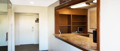 A registration desk with a wooden frame, a computer, and a map on the wall.