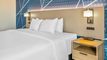 A hotel room with a neatly made bed, two wall-mounted nightstands, and a modern wall design.