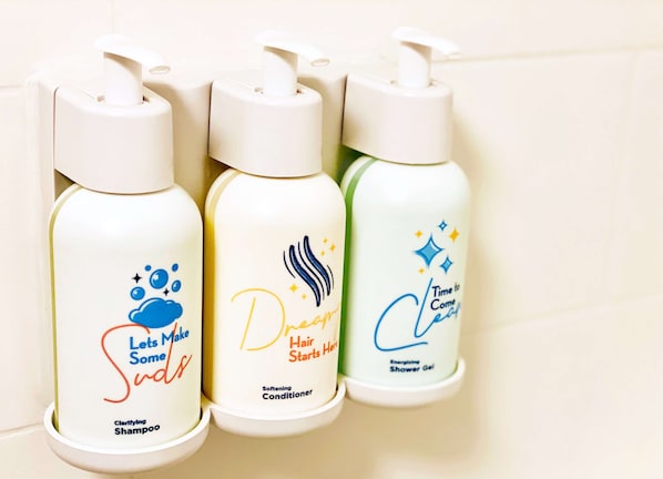 Three bottles of hair care products on a shelf.