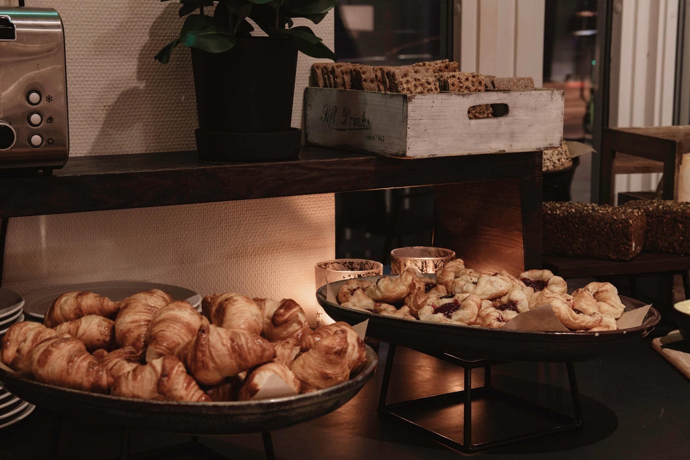 A buffet table with various baked goods, a vintage radio, and a potted plant.