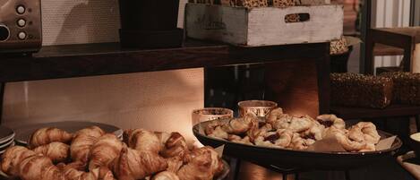 A buffet table with various baked goods, a vintage radio, and a potted plant.