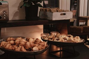 A buffet table with various baked goods, a vintage radio, and a potted plant.