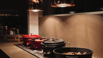 Una cocina con estufa, ollas y una encimera.
