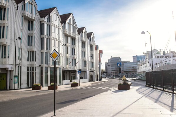 A row of white buildings with large windows and a pedestrian crossing.