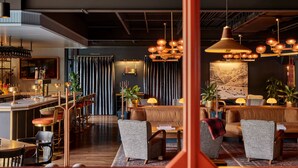 A modern hotel lobby with a bar area, seating, and a large painting on the wall. - High Country Motor Lodge – Near NAU/Downtown (Flagstaff)
