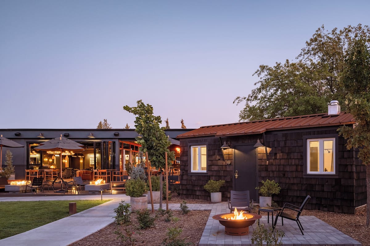 A modern house with a patio area featuring outdoor seating and a fire pit.