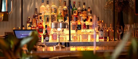 Un espace bar avec différentes bouteilles d’alcool et des verres.