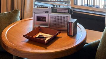 A wooden table with a radio, a leather case, and some books.