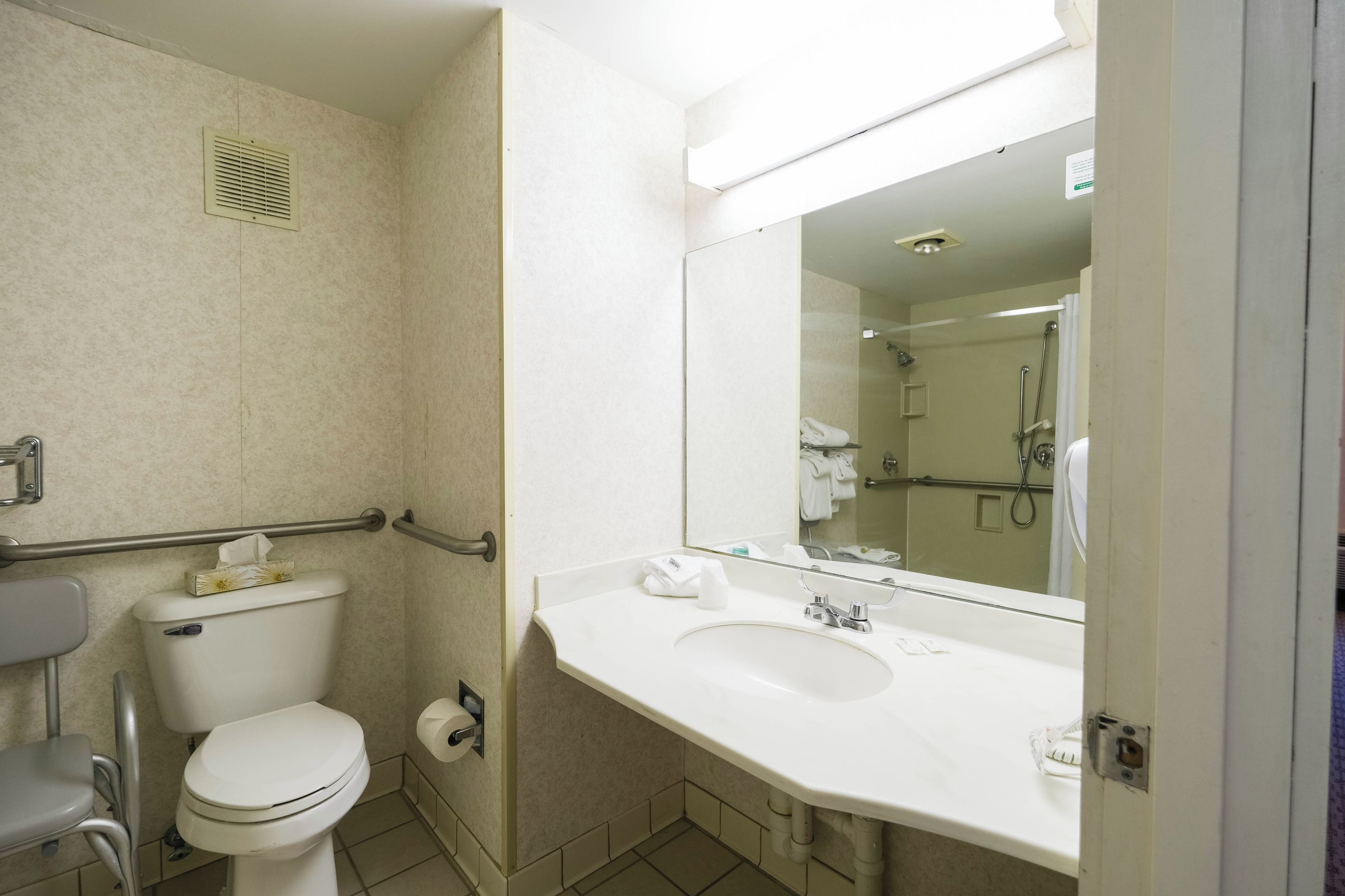 A standard hotel bathroom with a toilet, sink, and shower.
