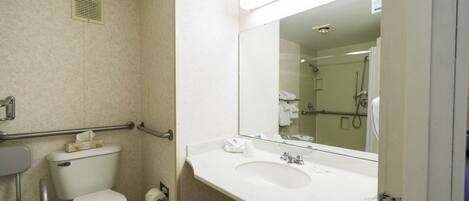 A standard hotel bathroom with a toilet, sink, and shower.