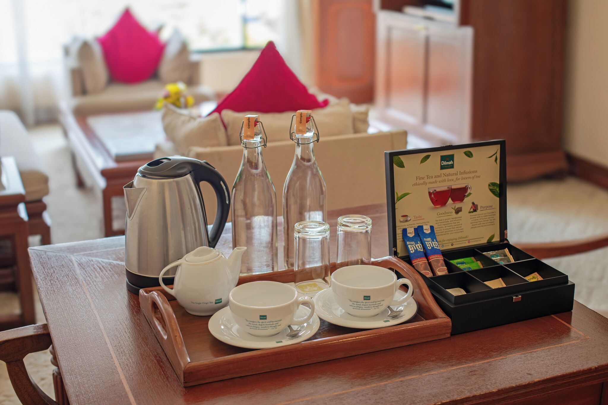 A tray with tea service items including a teapot, cups, and a box of tea bags.