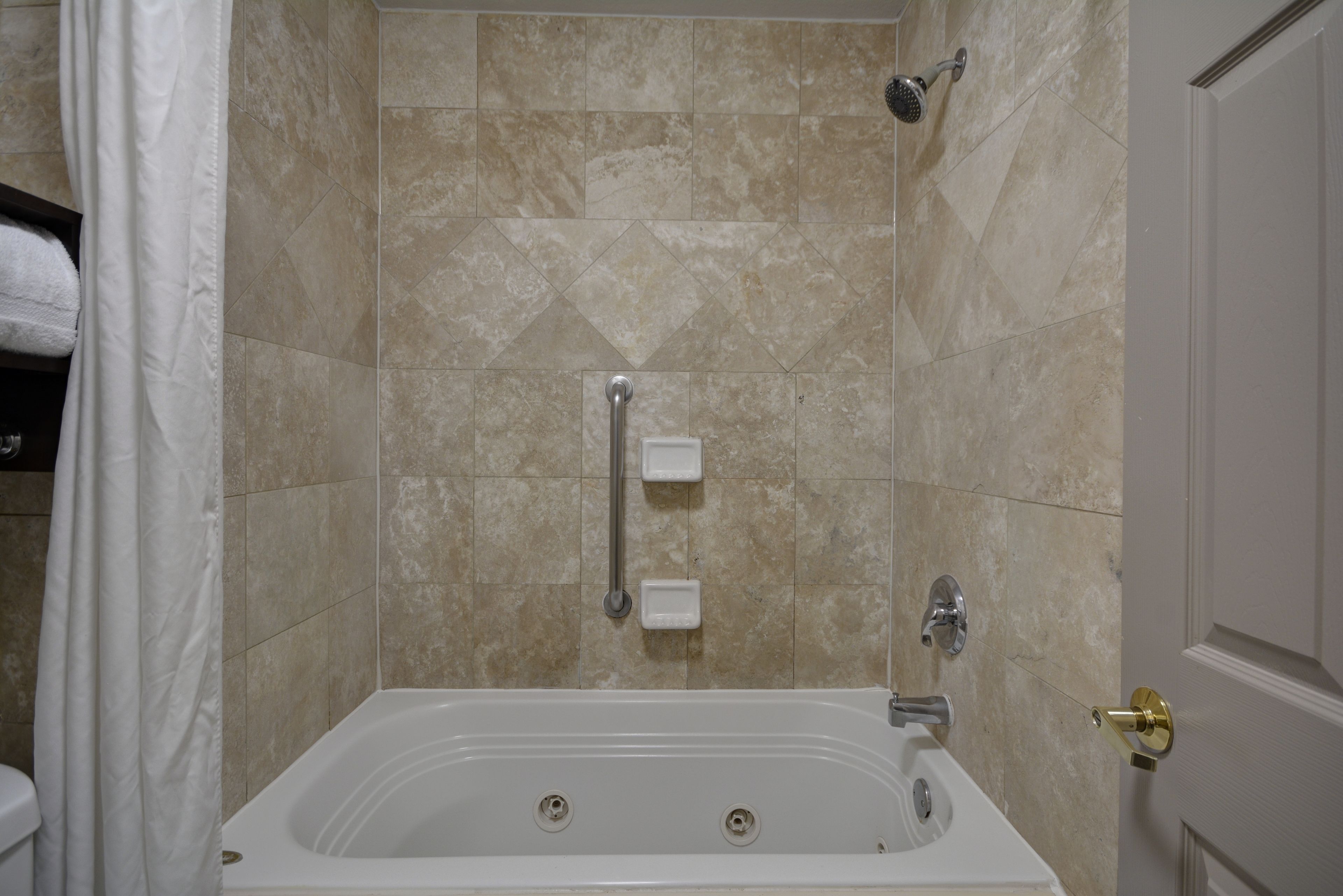 A bathroom with a bathtub, shower, and toilet.