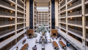 A multi-level atrium with a central garden, multiple dining areas, and balconies.